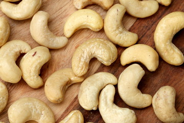 Raw cashew nuts on wooden table, top view