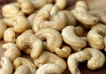 Raw cashew nuts on wooden table, detailed view