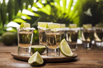 Gold tequila shots with lime fruits