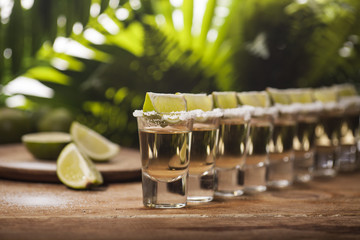 Gold tequila shots with lime fruits