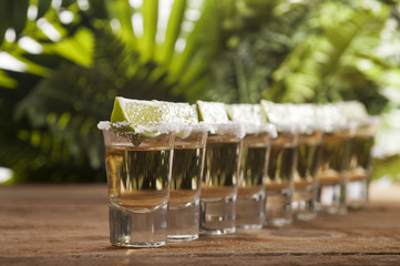 Gold tequila shots with lime fruits