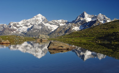 Naklejka na ściany i meble Alpine lake with reflection of mountains in water