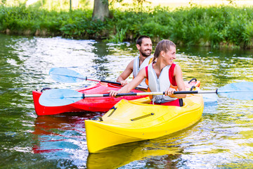 Freunde fahren im Kajak auf Wald Fluss