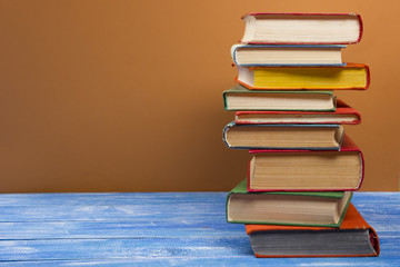 Stack of hardback books on wooden table. Back to school. Copy space for text