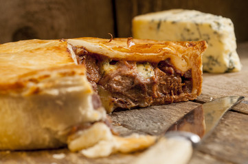 Sliced Meat Pie with Knife and Blue Cheese