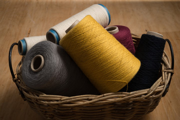 Fototapeta na wymiar Bunch of Spools of Thread in Woven Basket