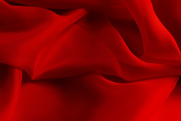 Shiny red silky fabric folds background texture