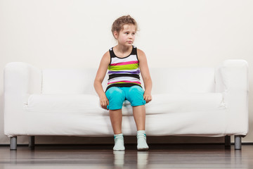 Fototapeta premium Tired exhausted lazy little girl kid sits on sofa