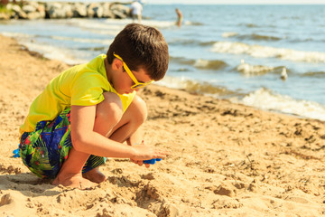 Little boy kid child with toy having fun on beach