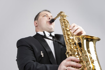 Obraz premium Music Themes and Ideas. One Caucasian Male Saxophonist Playing Sax