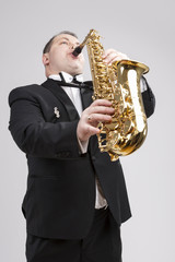 Fototapeta premium Music Themes and Ideas. One Caucasian Male Saxophonist Playing Saxophone