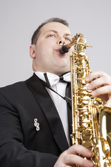 Fototapeta premium Music Themes and Ideas. One Caucasian Male Saxophonist Playing Saxophone