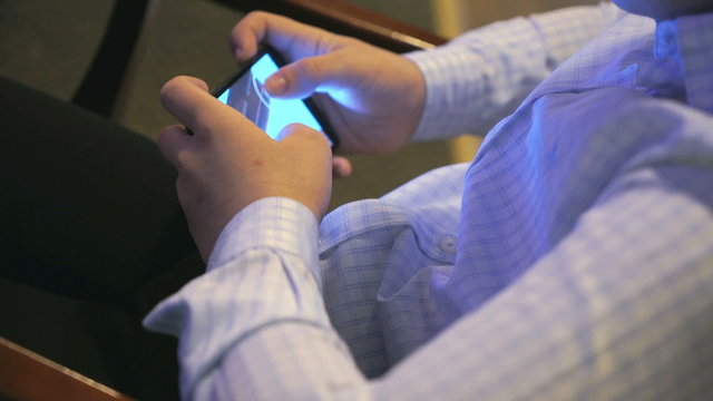 Boy playing a computer game on smart phone