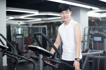 Fototapeta na wymiar young handsome man works out in modern gym