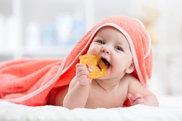 Fototapeten Cute baby with teether under a hooded towel after bath © Oksana Kuzmina
