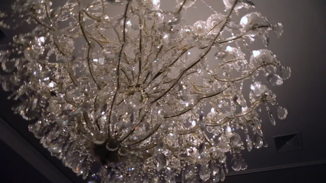 Beautiful retro luxury crystal strass chandelier isolated on a white wall of the restaurant.