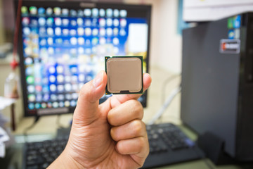 CPU in hand with desktop PC computer at office background. soft focus