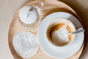 Top view coffee cup with a foam in wood tray.