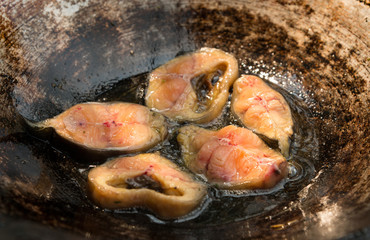 Fry fish Thai style food in hot oil in black pan