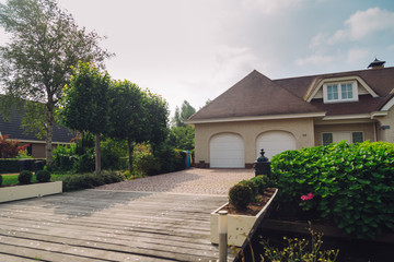 bushes, driveway and trees in front of the house