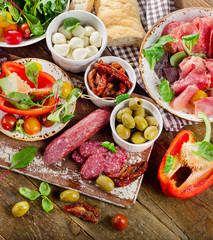 Appetizer set. Tomatoes, Meat, vegetables and cheese on wooden b