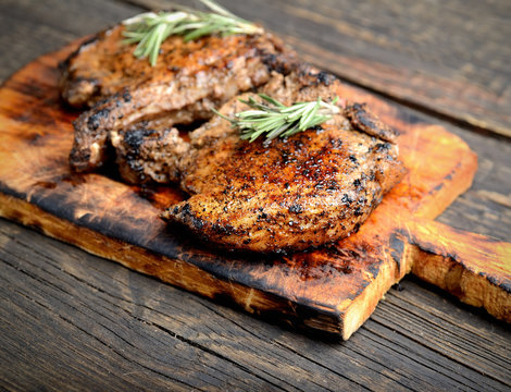 grilled steak with rosemary on a wooden background