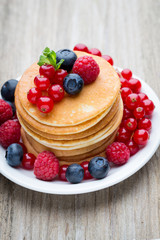 Stack of pancakes with blueberry and fresh berry.