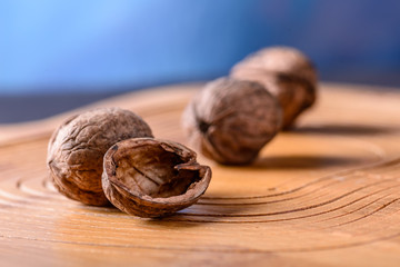 Three ripe whole walnuts in shell, one half of walnut