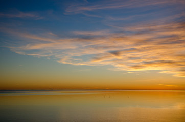 Colorful sunset by an absolutely calm water