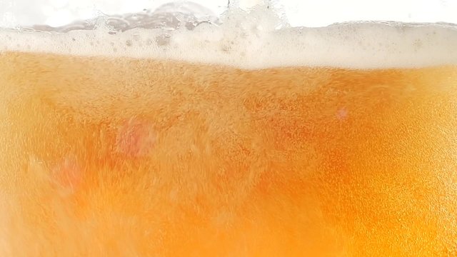 The bubbles floating up in the liquid of beer. Closeup. Slow motion