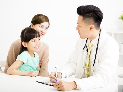 young doctor talking to young child and mother