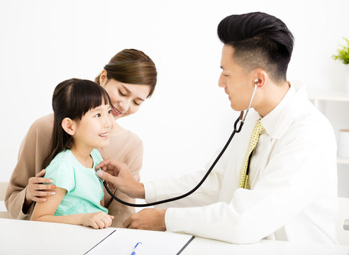 young medical doctor examining a little girl in office