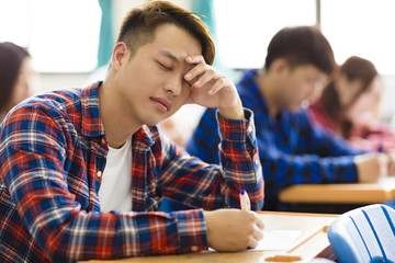 Stressed college student  for exam in classroom