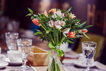 Flowers composition in restaurant, alstroemeria and tulips, combination of multiple colors