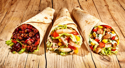 Front view of three burritos on table