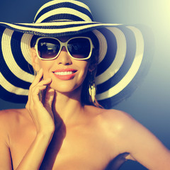 Stunning young woman in elegant hat and sunglasses