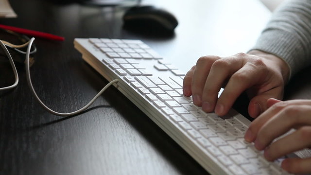 male hands typing on the keyboard, close-up