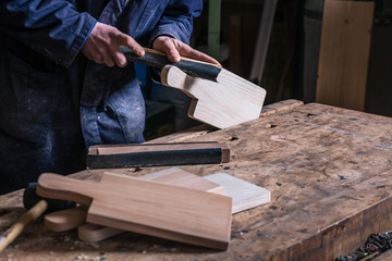 Carpenter sanding piece of Timber with sandpaper