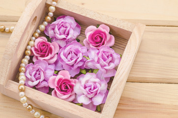 Pink roses in wooden box.