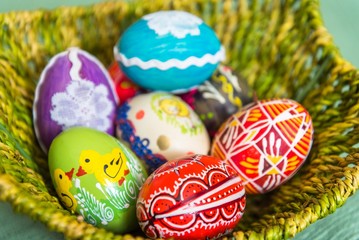 Closeup of beautiful colorful hand painted easter eggs in basket. Selective focus