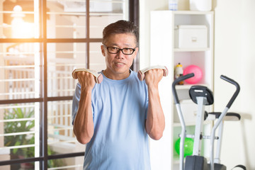 asian senior male with dumbell in the gym