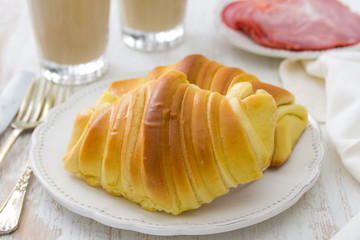 croissant with ham and glasses of coffee with milk