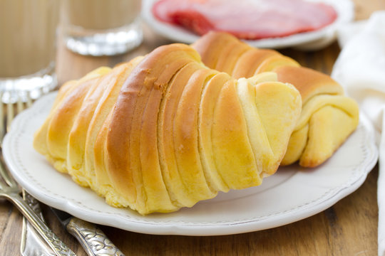 sweet bread with ham and glasses of coffee with milk