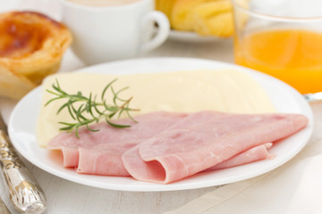 cheese and ham on plate with pastel de nata, juice and coffee