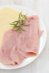 ham with cheese on white plate on white wooden background