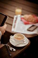 Young Man Eating Breakfast Whilst Using Tablet