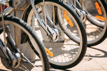 Fototapeta premium Row Of Parked Vintage Bicycles Bikes For Rent. Close Up Of Wheel