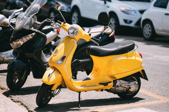 Yellow motorbike, motorcycle scooter parked in city