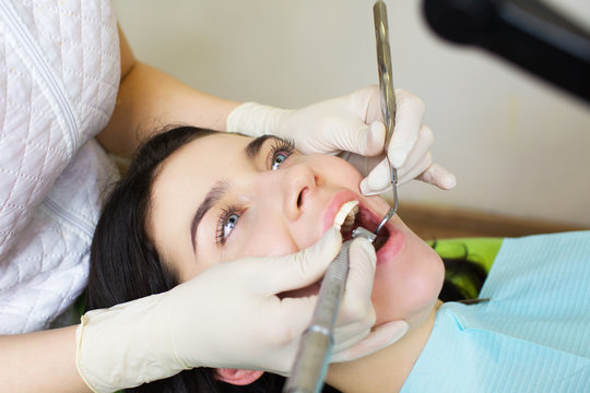 Dentist curing a female patient.Dentist  carrying out a thorough examination