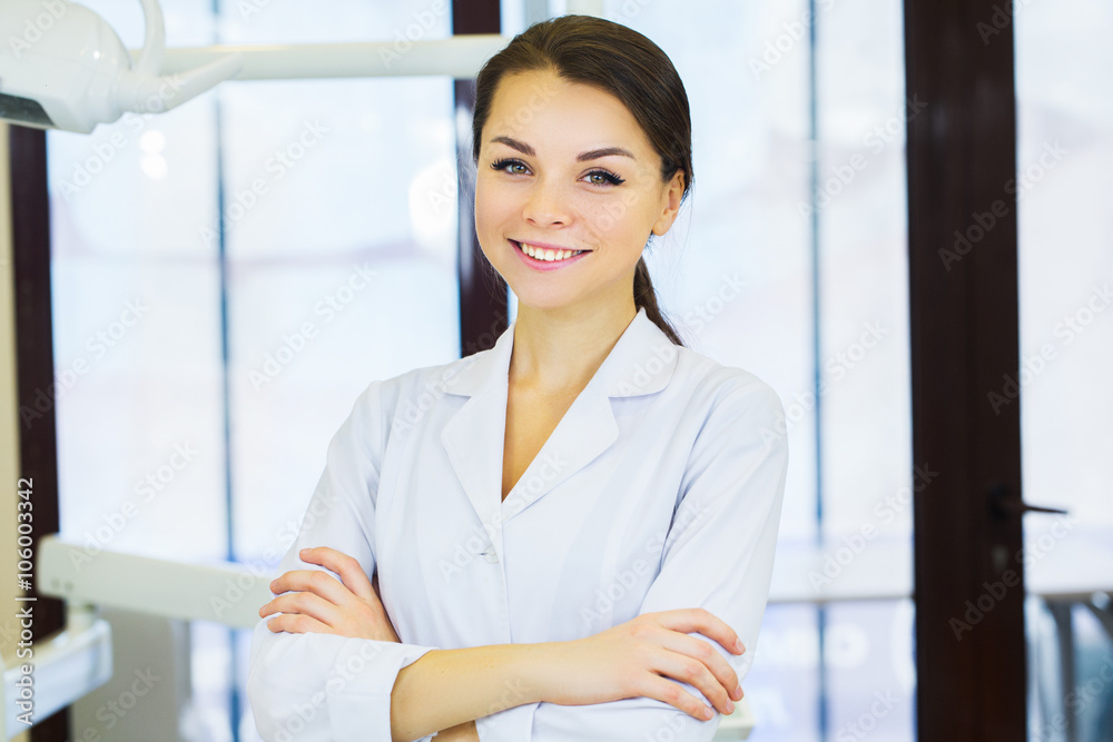 Wall mural people, medicine, stomatology and healthcare concept - happy young female dentist with tools over medical office background